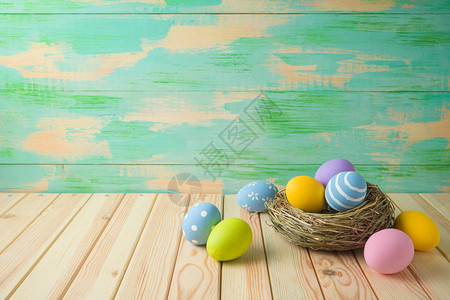 复活节假期背景与复活节彩蛋在木桌上的鸟巢图片