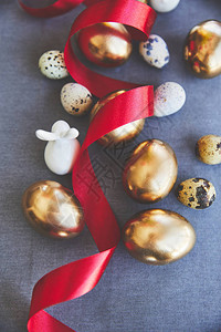 桌布上金色复活节彩蛋和鹌鹑蛋的顶视图图片