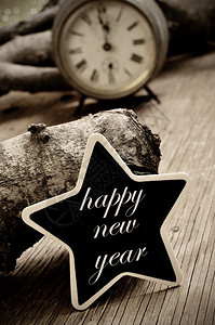 新年快乐写在恒星形的黑纸板上在生锈的木质表面上图片