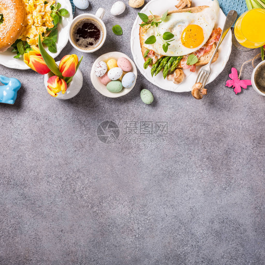 复活节早餐平铺有炒蛋百吉饼橙色郁金香面包吐司配煎蛋和绿芦笋彩色鹌鹑蛋和春假装饰品顶视图片