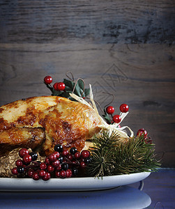 为感恩节或圣诞节午餐配有装饰品的烤火鸡餐盘上图片