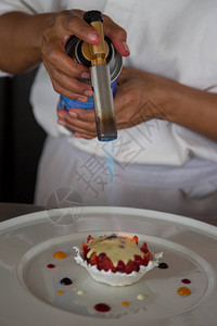 糕点师或厨师用小火烧焦糖布丁图片
