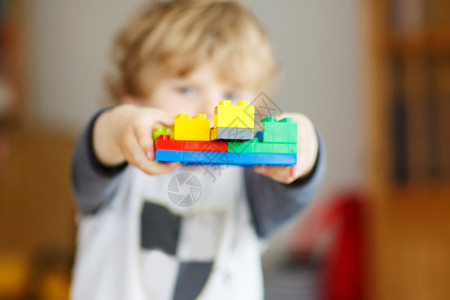 快乐的小男孩玩着建筑砖块建造了高塔有选图片