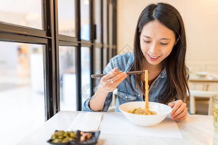 在中餐馆吃面条的女人图片