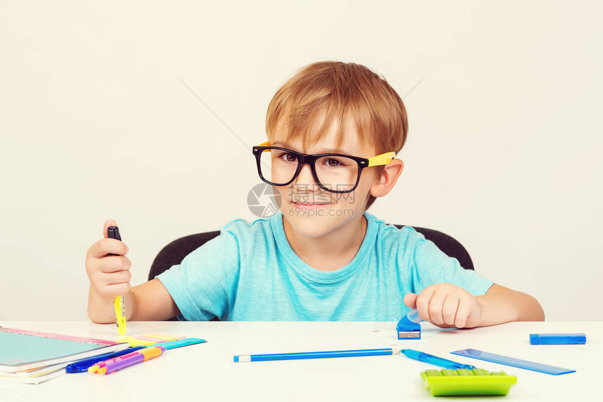 小学生男孩在课堂上学习和阅读书籍可爱的男生戴着眼镜做作业教育和回图片