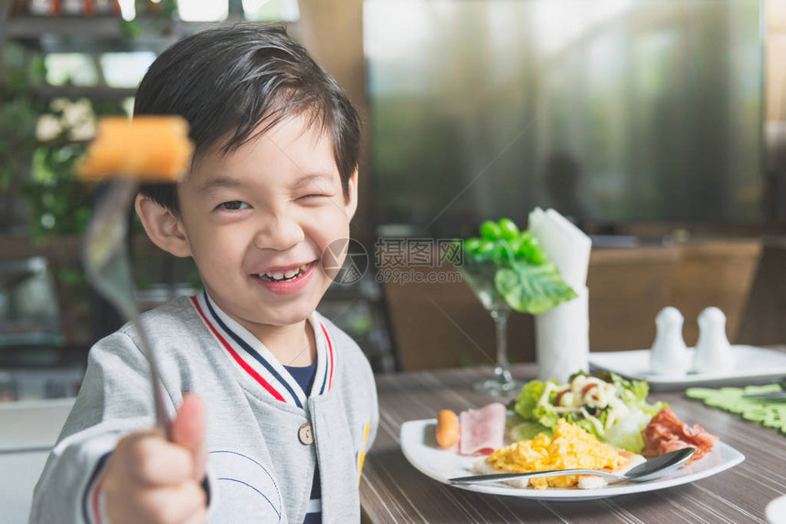 可爱的亚洲孩子在餐厅吃早餐图片