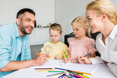 有两个小孩在家用彩色铅笔绘画的双图片
