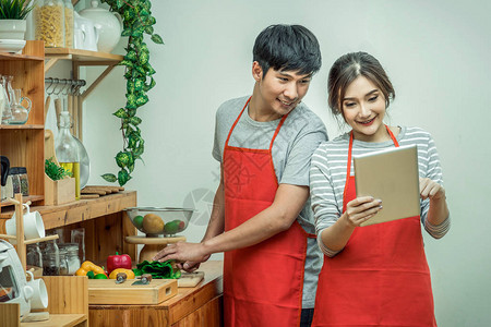 快乐的亚洲情人或情侣在现代房子夫妻和生活方式概念的厨房里图片