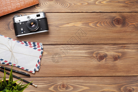 照相机和用品放在办公室木制桌上的办图片
