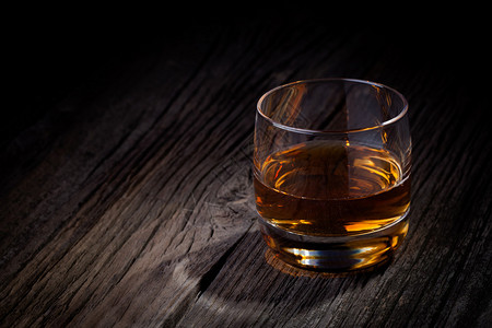 一杯豪华的单麦芽威士忌饮用旧木制桌子背景图片