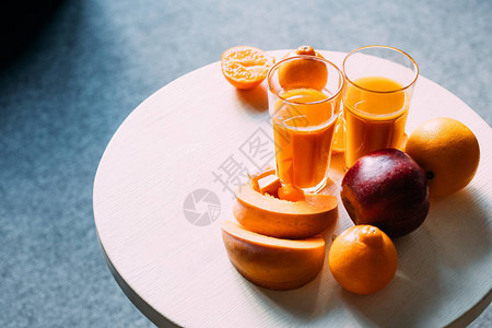 以南瓜在桌上的有机橙色冰沙和新鲜水果图片