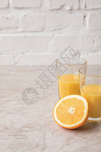 大理石桌面上的自制橙汁和橙子图片