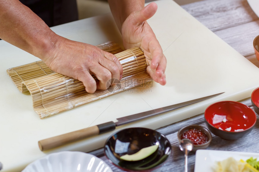 雄手握竹垫竹垫旁躺着刀子寿司咖啡馆熟练厨师日图片