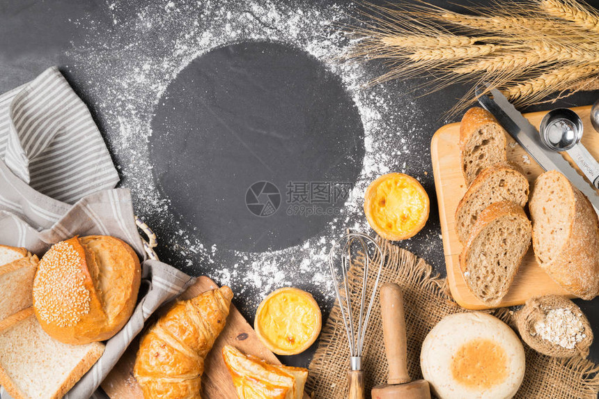 在黑石背景顶视图和复制空间上混合面包羊角面包法式面包松饼和蛋挞图片