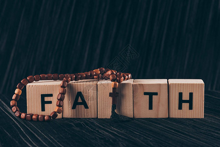黑色桌上带有字词Faith和十字的木高清图片