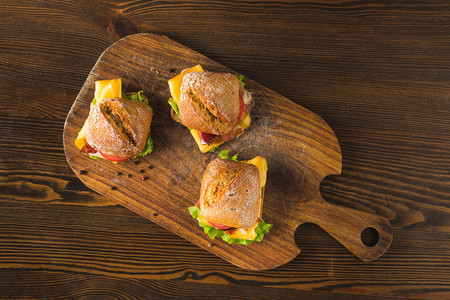3个三明治和木板上的奶酪和蔬图片