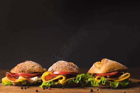 木板上带奶酪和蔬菜的三文治三明治图片