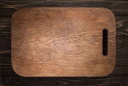 黑桌上木制切菜板的顶视图图片