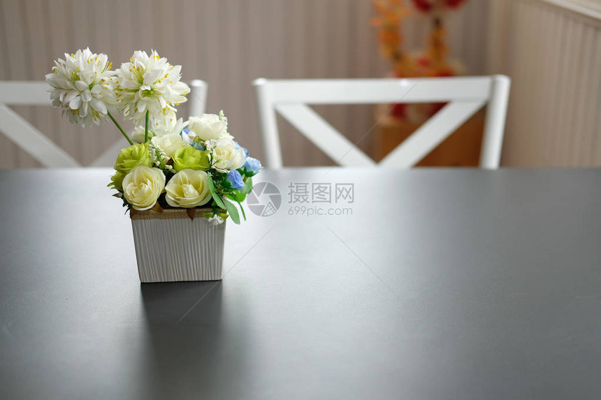 黑桌上的白椅子放在室内舒适的饭厅里图片