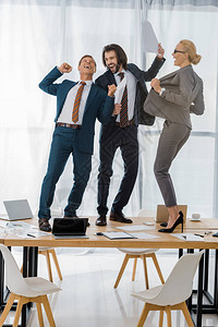 在办公室开会时在桌子上跳舞的保险业工人快乐图片