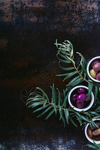 在破旧表面的碗中准备油的美味橄榄的顶部视图图片