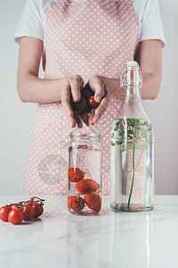 妇女将西红柿放入厨房加水图片
