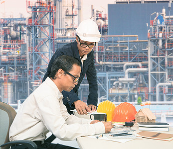 两名工程师在炼油厂外部工作台上工作图片