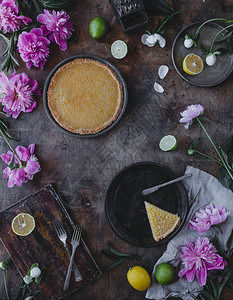 木桌上美味的柠檬派和牡丹的顶视图图片