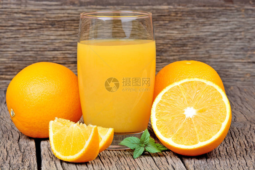 木桌上的橙汁玻璃杯图片