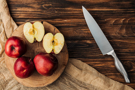 树桩刀和木桌布上红色美味苹图片