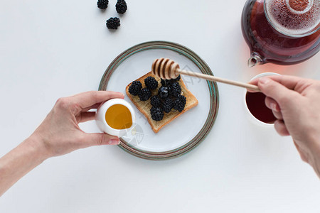 用茶和吐司浆果和蜂蜜作为早餐图片