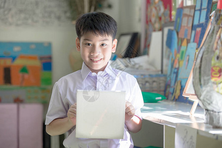 快乐的亚洲儿童在幼儿园展示他的手图片