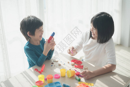 亚洲儿童在家里与多彩的模拟粘土一图片
