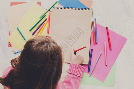 女孩用彩色标记蜡笔和铅笔绘画图片