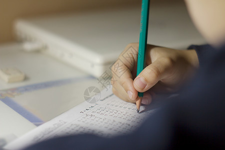 孩子解决数学例子孩子手里拿着铅笔带有乘法表示例的笔记本表学习乘法表的图片