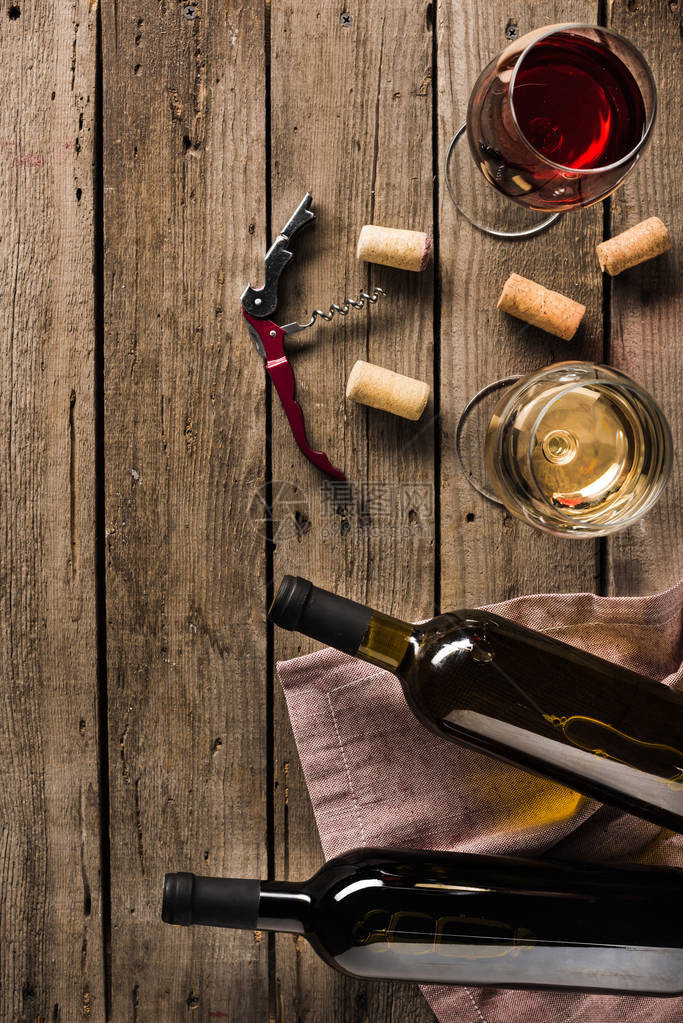 木板上两瓶葡萄酒corkscrew和葡萄酒玻璃以及复图片