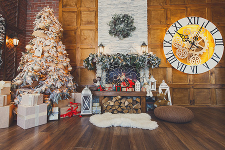 美丽的圣诞内饰温暖的房间里有壁炉装饰过的圣诞树很多礼物和木墙上的大钟寒假的舒适之背景图片