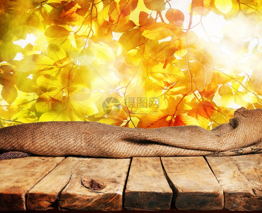 空的木桌和美丽的秋叶在背景中图片