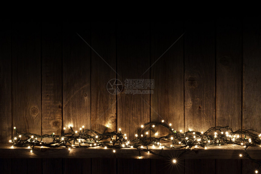 木墙背景上的圣诞灯图片