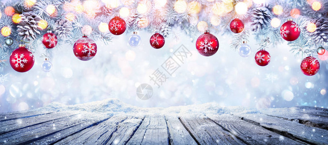 圣诞桌与红色挂球在雪白的背景图片