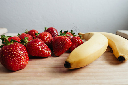 木桌上的草莓香蕉水果图片