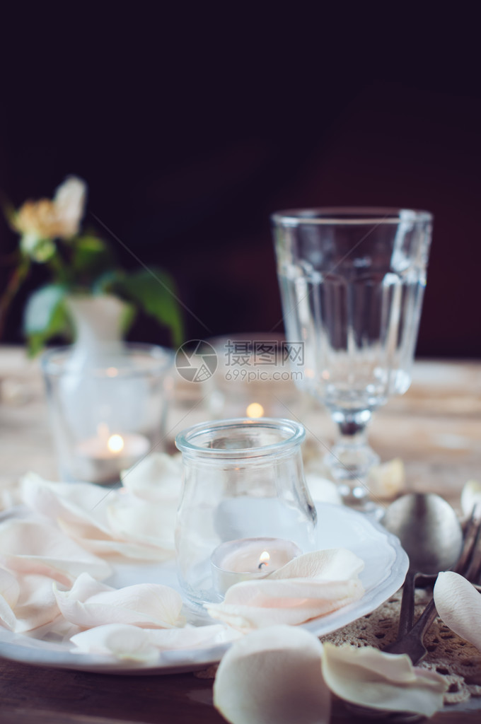 节日餐桌装饰玫瑰花瓣和蜡烛图片