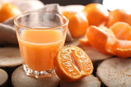 杯在木桌上的鲜美橘汁图片
