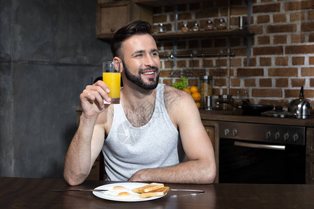 在家里吃早餐时喝果汁的英俊长图片