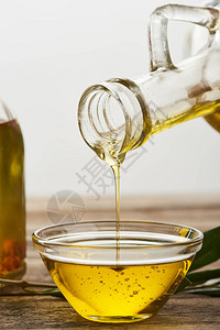 将橄榄油从瓶子倒入木图片