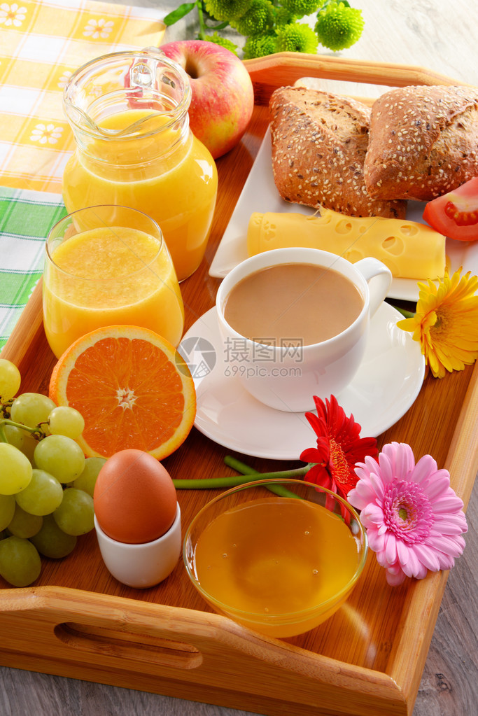 餐桌上的早餐有咖啡橙汁卷子和蜂图片