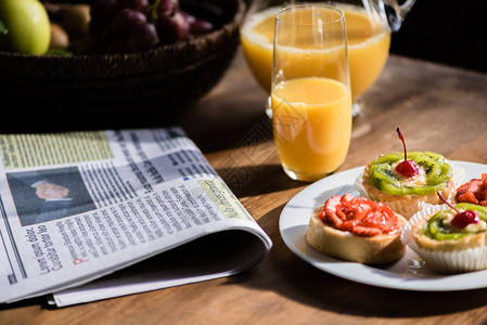 报纸早餐和蛋糕还有厨房桌上的果汁图片