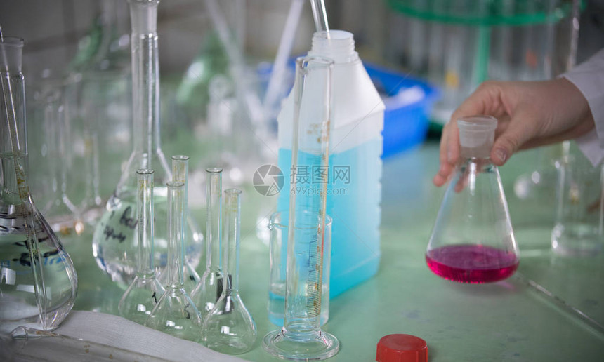 化学实验室触摸瓶子的手把桌子拉上来图片