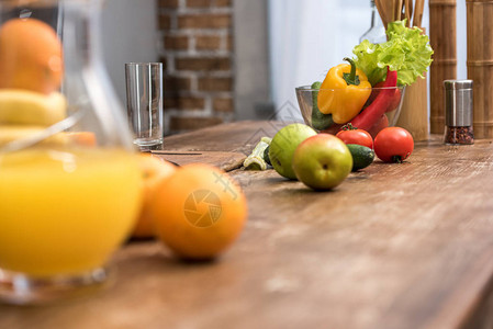玻璃罐中橙汁厨房桌上新鲜水果和蔬菜的选择焦点图片