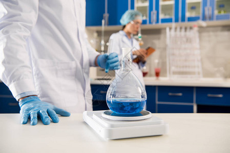 医务工作者在实验室用试剂对瓶子和试剂称重图片